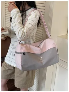 Large capacity pink gray travel duffel bag detail showing shoulder strap and zipper design.
