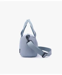 Side detail of light blue sports duffel bag showing strap buckle and woven tag.