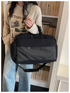 Detail view of a large capacity travel duffel bag with front grid pocket and sturdy handles.