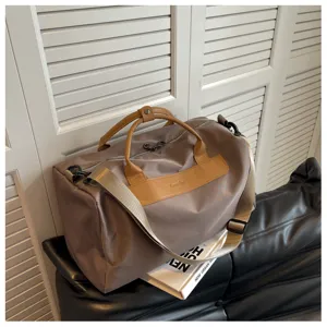 Detail view of large capacity travel duffel bag with brown leather handles and wet dry separation.