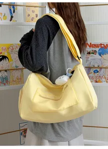 Detail view of the stylish yellow travel duffel bag showing its large capacity and front pocket.