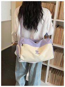 Detail shot of large capacity travel duffel bag in purple and beige color block style.