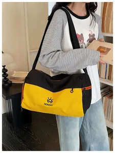 Detailed view of large capacity black and yellow travel duffel bag with shoulder strap.