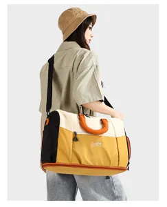 Vista dettagliata della borsa da viaggio colorblock di grande capacità con tracolla e manici.