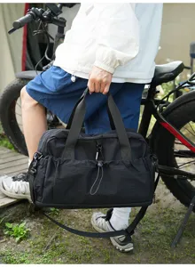 Durable black travel duffel bag detail showing strong handles and handy pockets for gym use.