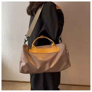 Close-up of the large travel duffel bag showing durable grey fabric and sturdy yellow handles.