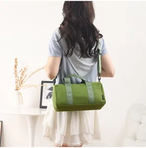 Small green cylinder sports gym duffle bag detail view, casual waterproof travel shoulder bag.