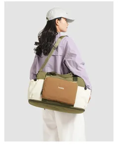 Nylon color-block travel duffel bag detail showing model carrying shoulder bag, spacious.