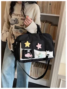 Detailed view of the stylish black and white travel fitness bag with cute plush star patches.