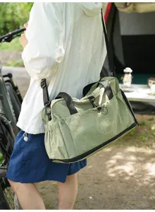 Detailed view of lightweight nylon travel duffel bag in light green with shoulder strap.