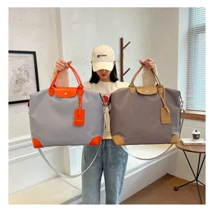 Travel bag detail view, nylon material with leather handle and stylish color blocking design.