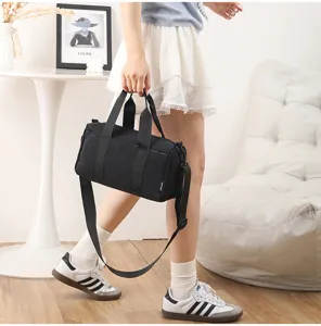Waterproof black cylindrical gym duffel bag for daily sports, fitness, and travel.