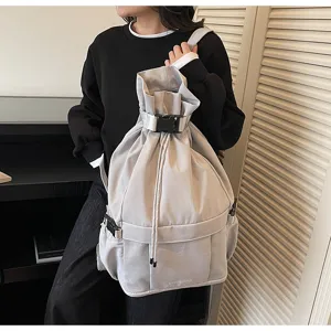 Detailansicht des lässigen grauen Kordelzug-Rucksacks mit Schnalle und Netztaschen für Reisen.
