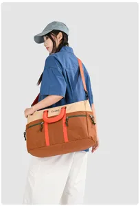Color-blocked travel duffel bag with large capacity, durable fabric and orange straps.
