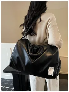 Detailansicht der großen schwarzen Reisetasche aus Weichleder, bequem und stilvoll.