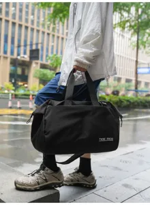 Waterproof black travel duffel bag detail, large capacity gym bag for short trips and sports.