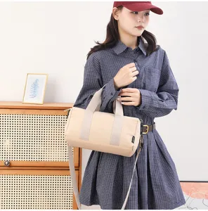 Compact canvas barrel bag with top handles and adjustable strap for casual daily use.