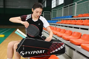 Detailed view of the large capacity badminton racket bag with handle in sport hall scene.