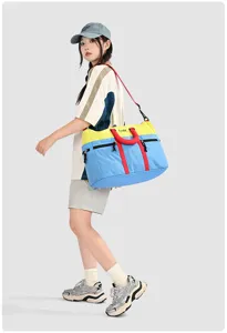 Detail view of color-blocking travel duffel bag, showing spacious compartment and durable handle.
