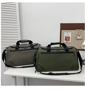 Vue détaillée de deux grands sacs de voyage vert foncé et gris posés sur un bureau propre.