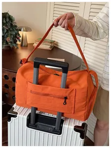 Large capacity orange travel duffel bag with luggage sleeve for short trips and fitness.