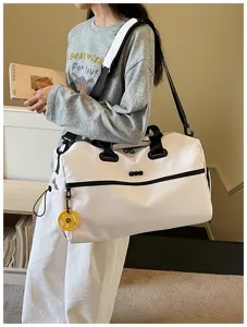 Grand sac de voyage blanc avec des sangles noires, design pratique et moderne pour le sport.