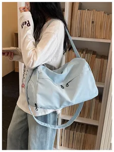 Lightweight blue travel duffel bag with large capacity and shoulder strap for gym trips.