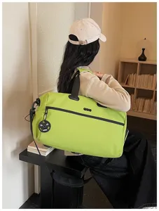 Vue détaillée d'un grand sac de voyage vert citron avec des poignées solides et durables.