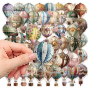 Detailed shot of vintage hot air balloon sticker in hand, showcasing transparent material.