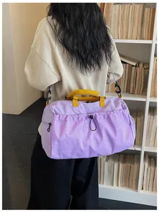 Vista detallada de la bolsa de viaje morada clara con asas amarillas y bolsillo de rejilla.
