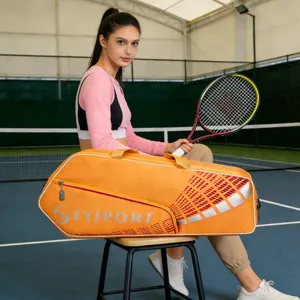 Close-up view of large capacity orange sports bag with racket on tennis court setting.