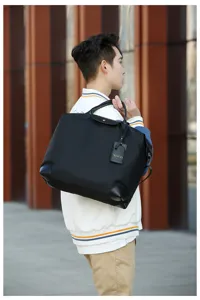 Stylish black nylon travel duffel bag with leather handles and spacious interior storage.