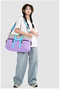 Detailed view of large capacity color block travel duffel bag with shoulder strap and handles.