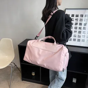 Minimalist pink travel duffel bag with large capacity, shoulder strap and gym storage design.