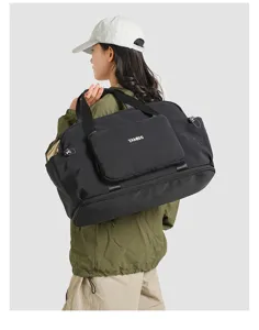 Black nylon travel duffel bag with wet dry separation and expandable design for hiking.
