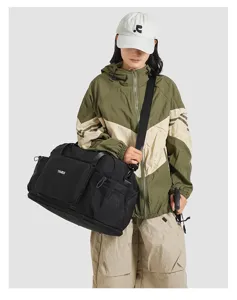 Detail view of black nylon travel duffel bag featuring handy front pocket and durable strap.