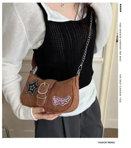Y2K millennium style brown baguette shoulder bag with star and Omg patches worn by a model
