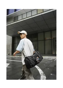 Detail shot of a black sports duffel bag with a stylish patch, ideal for gym and travel.