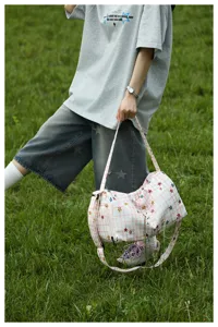 Detail shot of the pink plaid travel duffel bag featuring colorful star prints, outdoor.