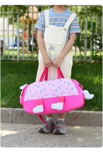 Detail shot of pink kids waterproof travel duffel bag with cute unicorn and rainbow prints.