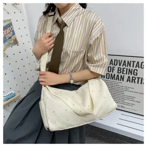 Detailed view of casual canvas travel duffle bag with colorful polka dots and side pocket.