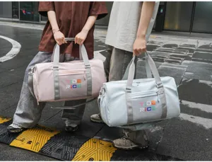 Detailed shot of trendy travel gym bags in pink and light blue, featuring dual carry options.