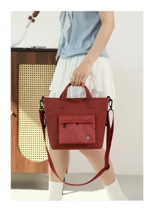 Detail shot of red canvas crossbody bag with plaid front pocket, ideal for daily commute.
