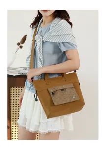 Detailed view of a casual brown tote bag with plaid front pocket, perfect for daily commuting.