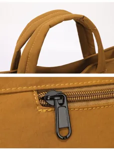 Bag detail close-up showing reinforced handle stitching and smooth metal zipper pull.