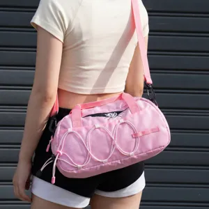 Pink waterproof outdoor sports gym bag with bungee cords and shoulder strap for travel.