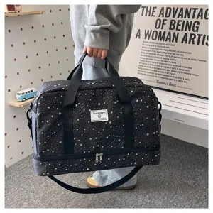 Detailed view of black star print travel duffel bag with shoulder strap and bottom compartment.