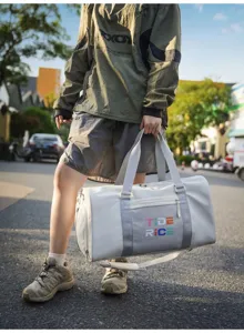 Detailed outdoor close-up view of the fashionable grey sports duffel bag with colorful prints.