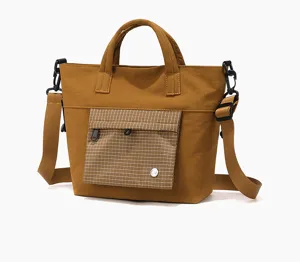 Casual brown tote bag with crossbody strap, grid front pocket, stylish commuter handbag.