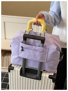 Large capacity travel duffel bag with luggage sleeve, yellow handle wrap and front pocket.